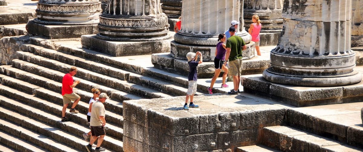 Visitors climbing the marble steps of an ancient temple
