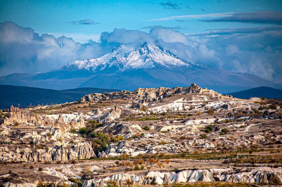 Snow-capped Mount Erciyes rising behind the eroded rock ridges of Cappadocia